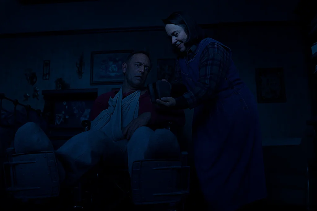 Annie Wilkes holding a sledgehammer beside Paul Sheldon’s bed in Misery, depicting the real-life inspired psychological thriller by Stephen King.