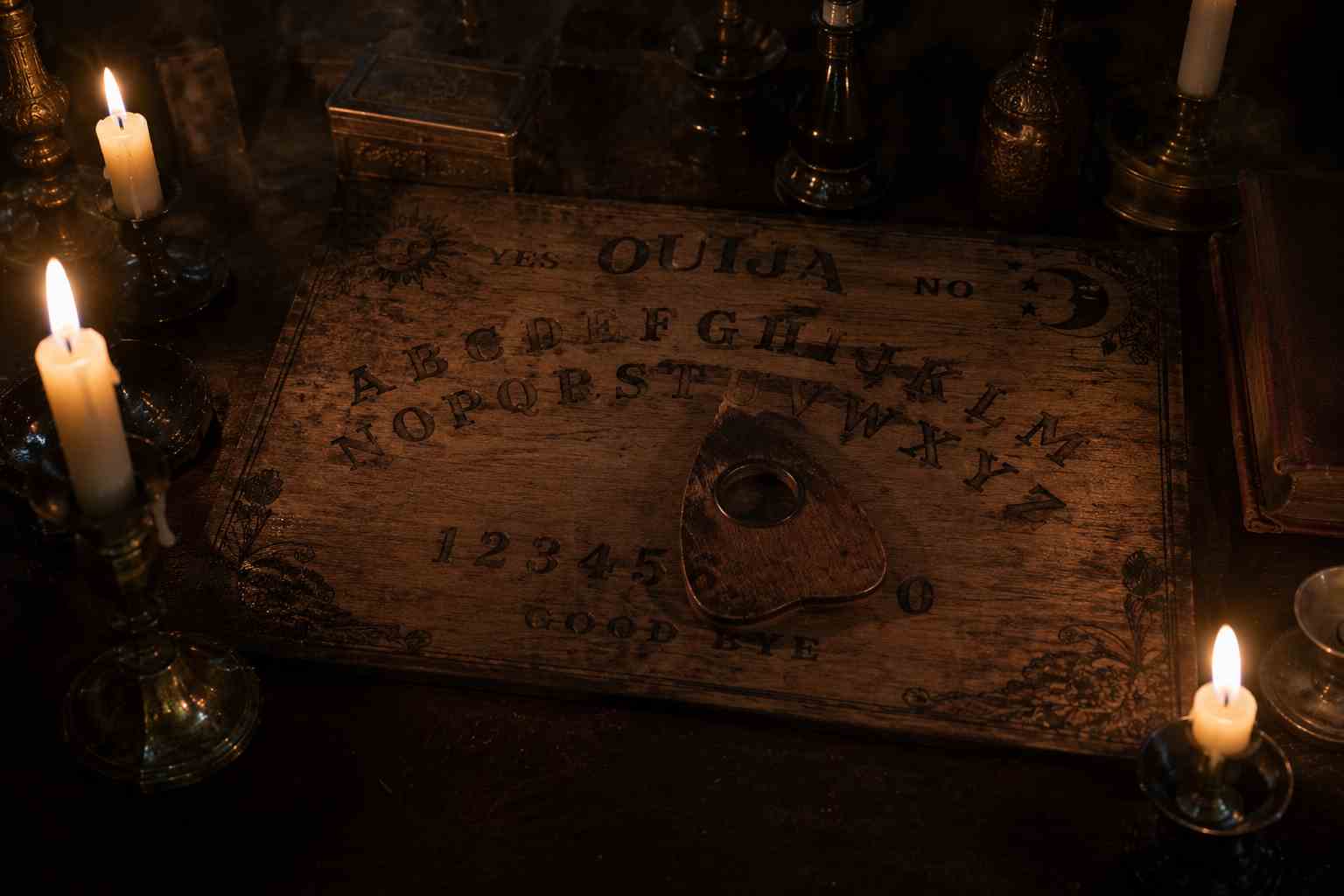 Vintage Ouija board with candles inspired by the real history behind the Ouija movie